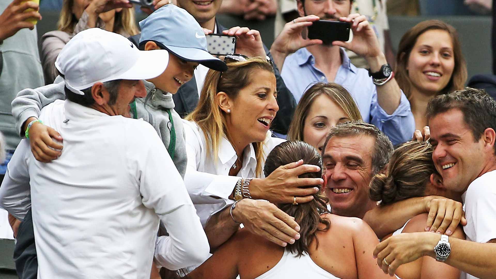 <a href='https://www.atptour.com/en/players/federico-cina/c0nb/overview'>Federico Cina</a> in the arms of his father, Francesco (far left), at <a href='https://www.atptour.com/en/tournaments/wimbledon/540/overview'>Wimbledon</a> in 2014, following Sara Errani and Roberta Vinci's title run.