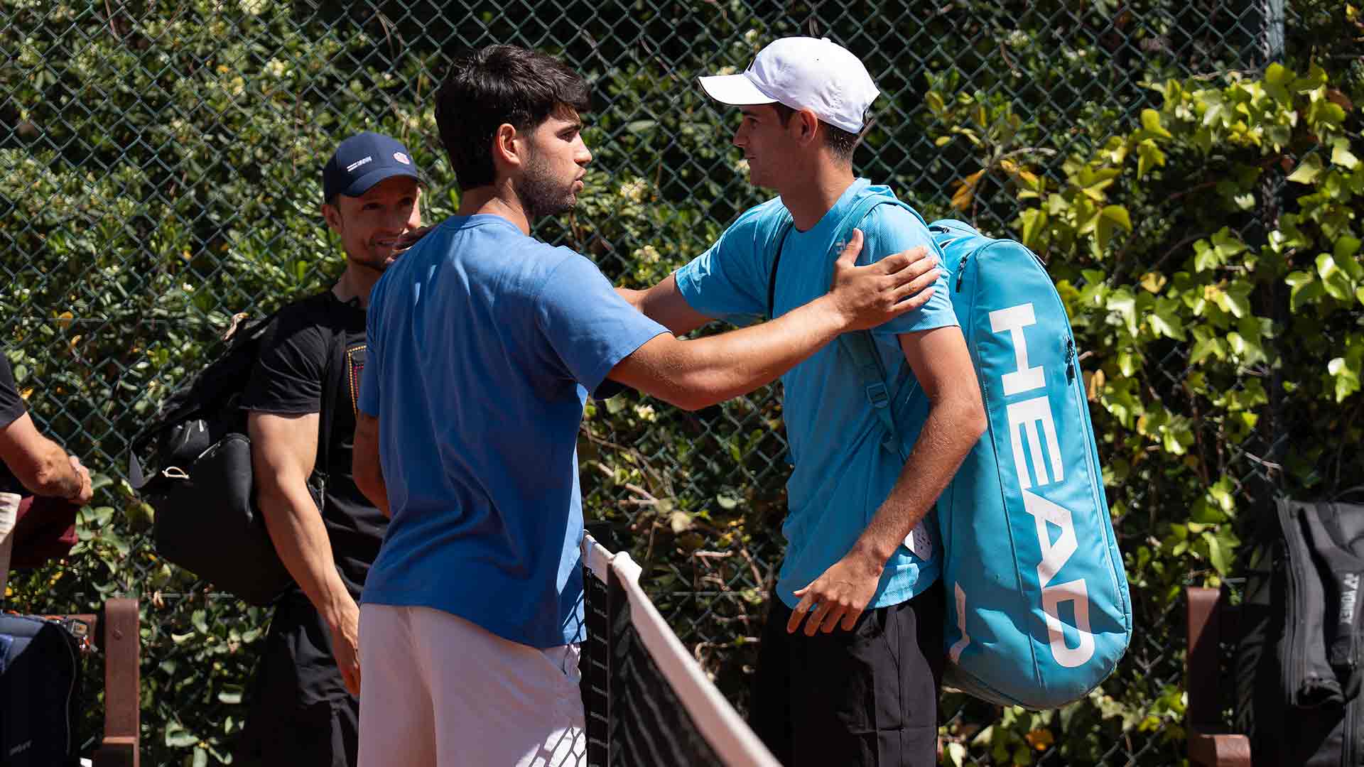 Carlos Alcaraz y Rafael Jódar se saludan en la pista de entrenamiento en Barcelona.