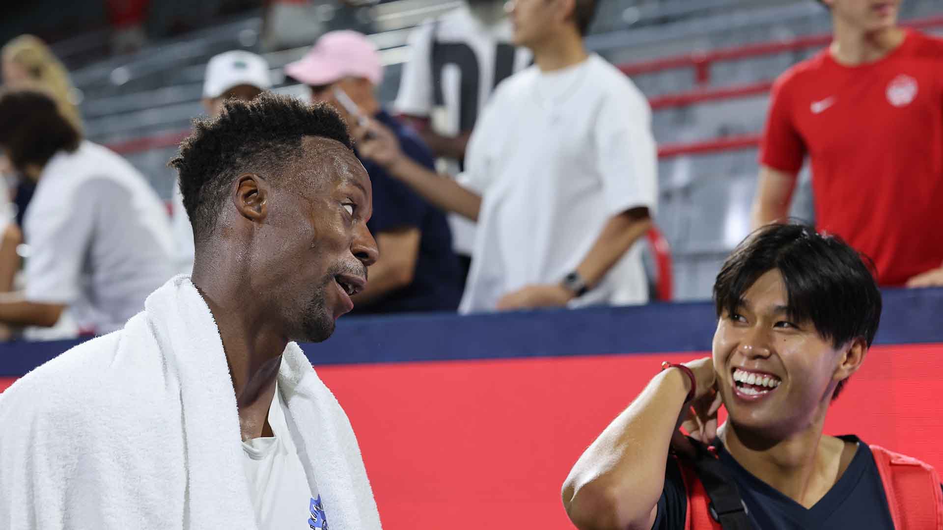 Gael Monfils signs a tennis ball for Learner Tien in Montreal on Wednesday. 