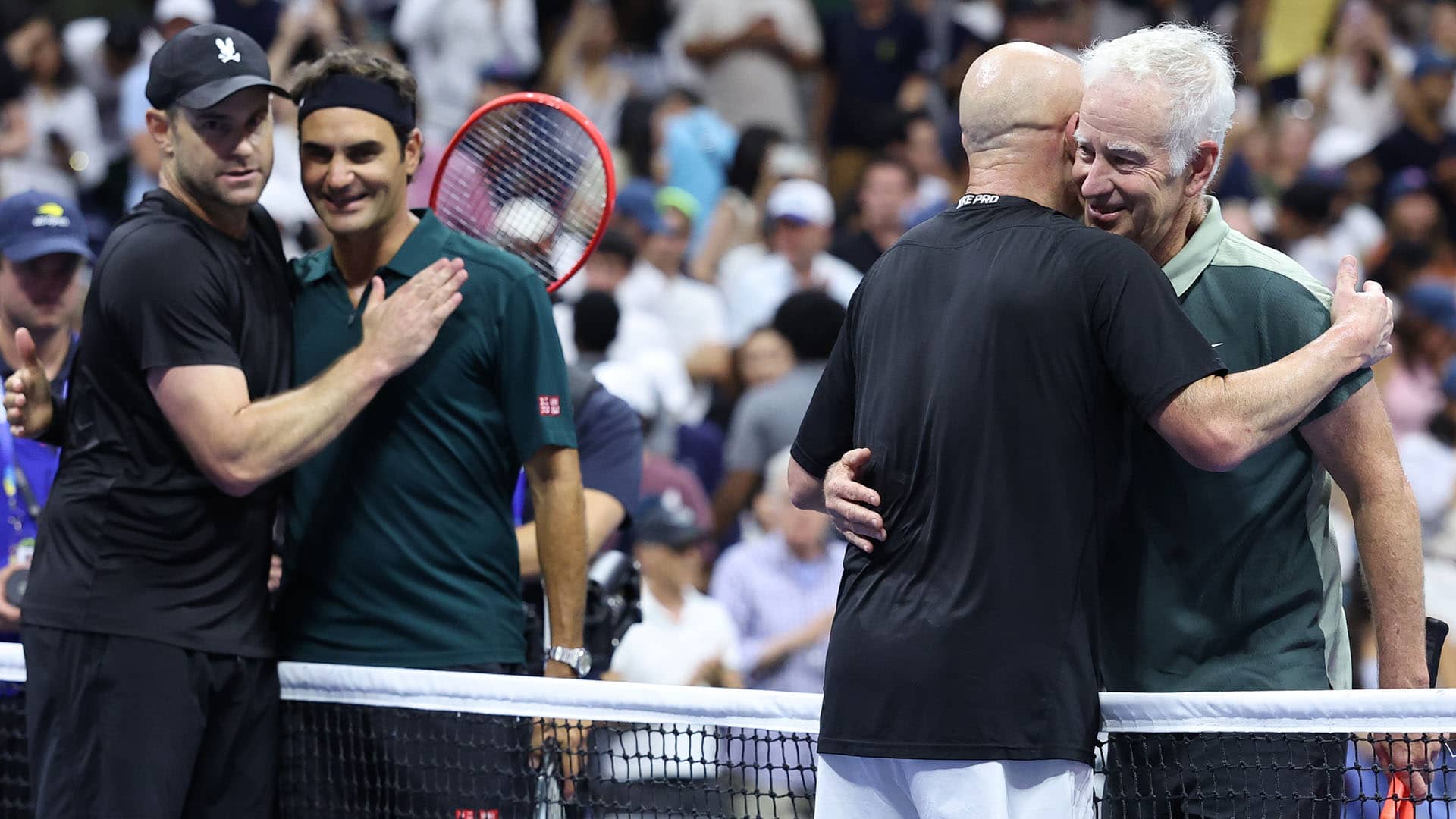 <a href='https://www.atptour.com/en/players/roger-federer/f324/overview'>Roger Federer</a> embraces <a href='https://www.atptour.com/en/players/andy-roddick/r485/overview'>Andy Roddick</a> while <a href='https://www.atptour.com/en/players/john-mcenroe/m047/overview'>John McEnroe</a> hugs <a href='https://www.atptour.com/en/players/andre-agassi/a092/overview'>Andre Agassi</a>.