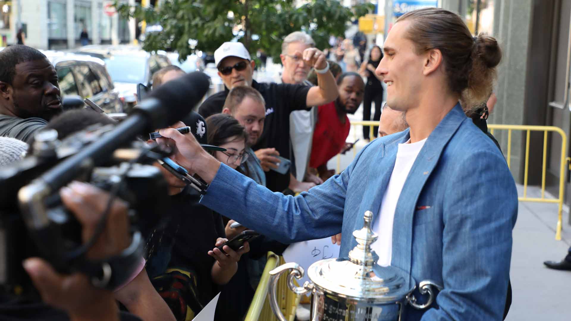 <a href='https://www.atptour.com/en/players/alexander-zverev/z355/overview'>Alexander Zverev</a> signs autographs for fans in New York.