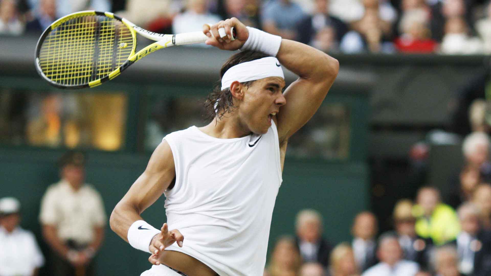 Rafael Nadal outlasts five-time defending champion Roger Federer 6-4, 6-4, 6-7(5), 6-7(8), 9-7 to win his maiden Wimbledon title.